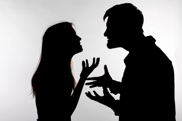Aggression and abuse concept - man and woman expressing domestic violence in studio silhouette isolated on white background