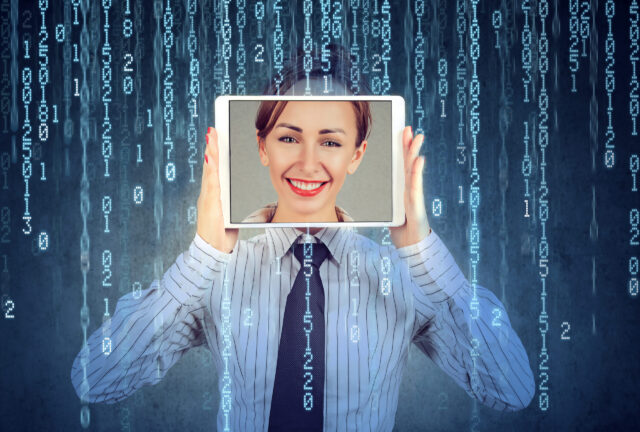 A person in a shirt and tie holds a tablet in front of their face, displaying a smiling face. The background features cascading digital code, subtly hinting at technology and the risks of identity theft.