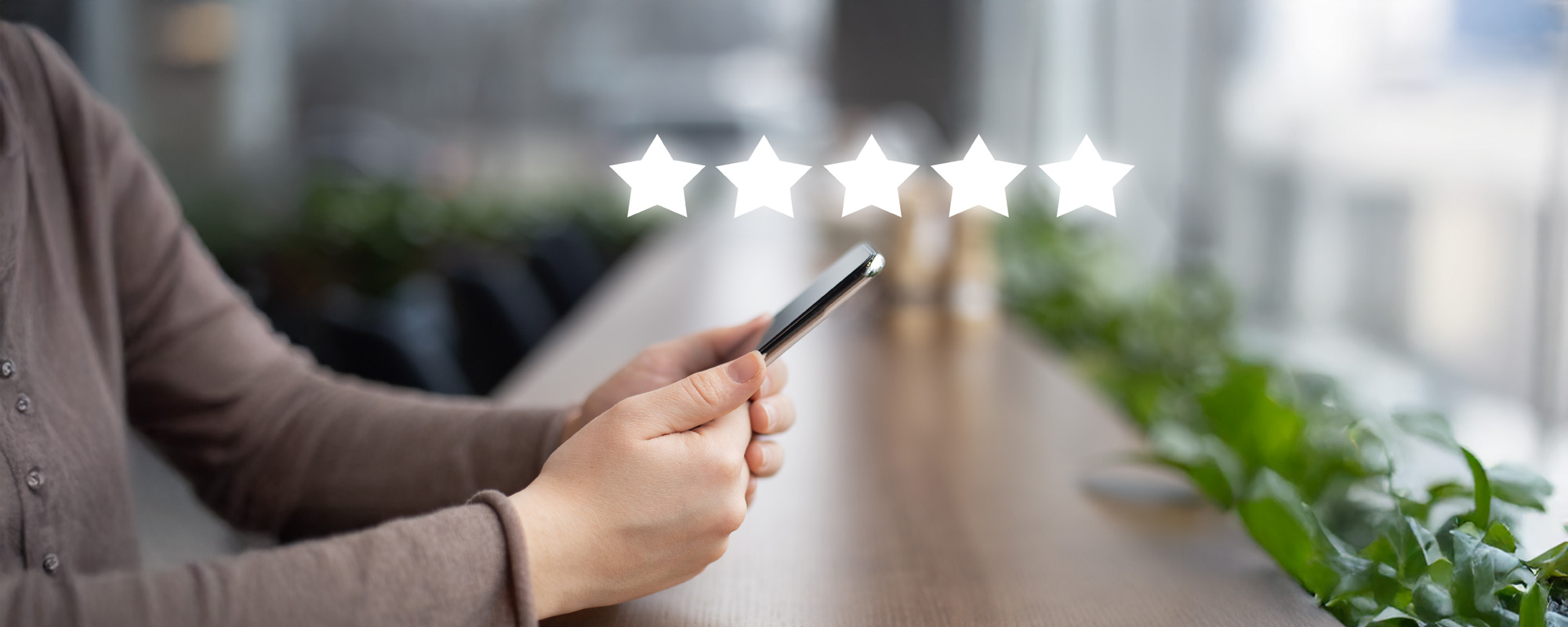 Woman evaluating mobile app on cellphone cafe background